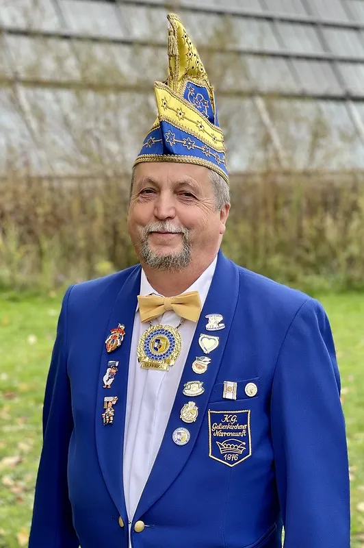 Porträt von Jürgen Lübke im blauen Sitzungsjackett mit Narrenkappe