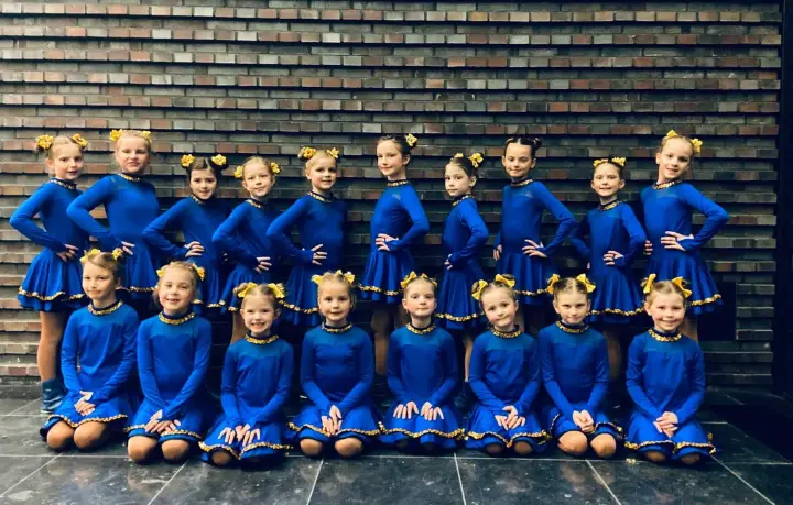 Minigarde: Gruppenfoto der Kinder in blauen Kostümen mit gelben Haarschleifen