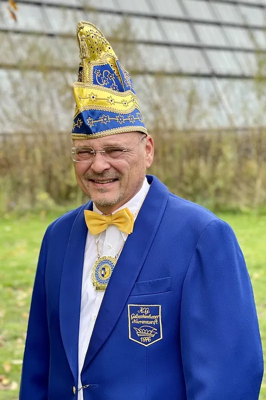 Porträt von Peter Honnerlage im blauen Sitzungsjackett mit Narrenkappe