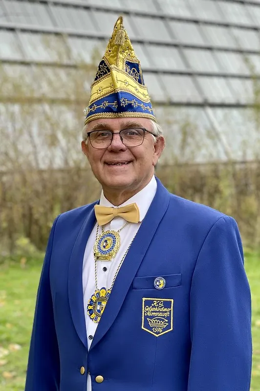 Porträt von Uwe Gemsa im blauen Sitzungsjackett mit Narrenkappe